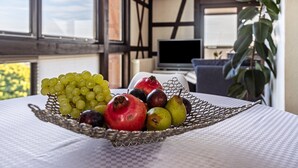 Una mesa con una cesta de frutas que contiene uvas, granada y peras.