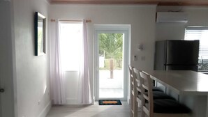 A kitchen with a wooden ceiling, a refrigerator, and a window. - 960 Sq. ft  Beach  Front Villa located in Steventon, Exuma,  Bahamas . (Steventon)