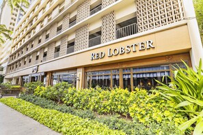 A hotel with a name sign 'RED LOBSTER' and a multi-story building with balconies. - Prime Waikiki Studio – Walk to the Beach! (Honolulu)