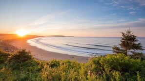 Ranta lähistöllä, aurinkotuoleja, rantapyyhkeitä