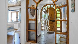 A wooden door with a glass panel and a decorative metal piece. - Beautiful private villa for 20 people with WIFI, TV, terrace and pets allowed (Bremerhaven)