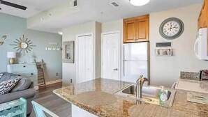 A modern kitchen with granite countertops, stainless steel appliances, and wooden cabinets.