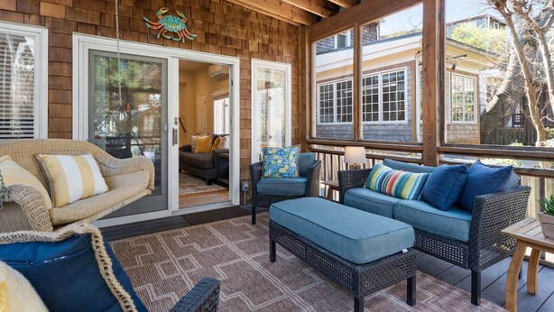 A covered porch with wicker furniture, a wooden ceiling, and large windows. - Historic Happy Home Steps from Main Street w Private Yard, Screened-In Porch & Parking (Annapolis)