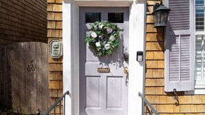 A white door with the number 117, a wooden fence, a metal gate, and a wooden wall with a window and shutters. - Historic Happy Home Steps from Main Street w Private Yard, Screened-In Porch & Parking (Annapolis)