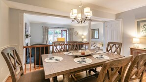 Un coin repas avec une table en bois, des chaises et un lustre.