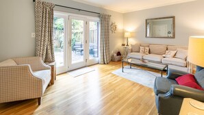 Un salon spacieux comprenant un ensemble de canapés, une table basse et un fauteuil à motifs.