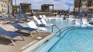 A swimming pool with lounge chairs and sun umbrellas, surrounded by buildings. - Monthly Stays Luxe Des Peres Suite with Complimentary Starbucks Onsite!  (Des Peres)