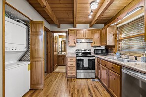 Kitchen features a central island, stainless steel stove, microwave, and oven.