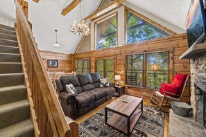 Relax in this inviting living area with a leather sofa, coffee table, and stone fireplace.