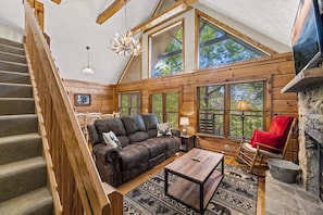 Relax in this inviting living area with a leather sofa, coffee table, and stone fireplace.