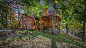 Eine Holzhütte mit Veranda und einer Treppe, die zu einer Terrasse führt.