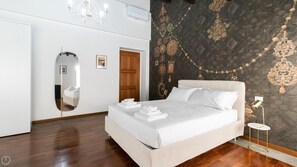 Relax in a stylish room with a large bed, full-length mirror, and elegant tapestry.