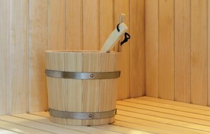 A wooden sauna with a metal bucket and a wooden mallet. - Promenadenvilla (Lübeck)