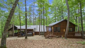 A cabin with a covered porch and a separate building with a chimney. - Bent Pine Lodge | Spacious 4BR Broken Bow Cabin with Hot Tub, Fire Pit & Grill (Hochatown)