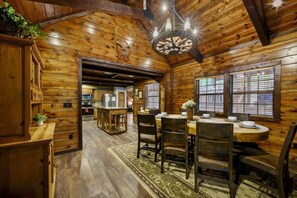 A wooden interior with a dining area, kitchen, and a chandelier. - Bent Pine Lodge | Spacious 4BR Broken Bow Cabin with Hot Tub, Fire Pit & Grill (Hochatown)