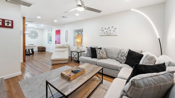 A modern living room with a sofa, coffee table, and ceiling fan. - Townley on 6th! (Phoenix)