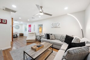 A modern living room with a sofa, coffee table, and ceiling fan. - Townley on 6th! (Phoenix)