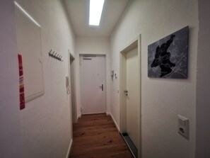 Stylish hallway with a modern design, featuring a framed artwork and functional elements.