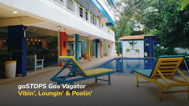 A two-story building with a pool area, outdoor seating, and potted plants. - goSTOPS PLUS Goa, Vagator (Vagator)