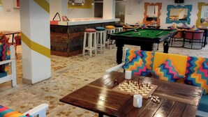 A vibrant lounge area with a pool table, bar, and colorful seating. - goSTOPS PLUS Goa, Vagator (Vagator)