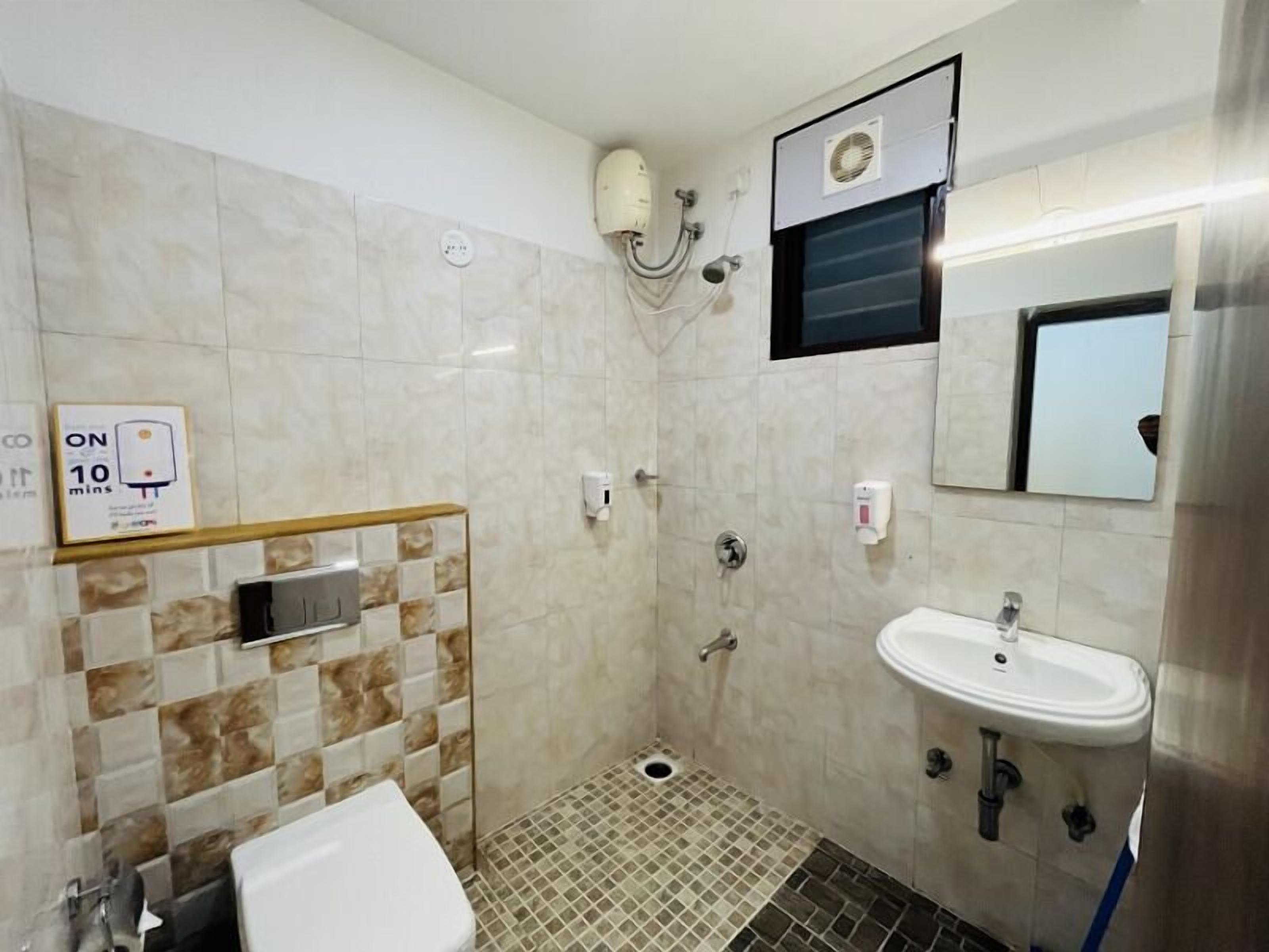 A small bathroom with a toilet, sink, and shower. There is a sign indicating a 10-minute limit.