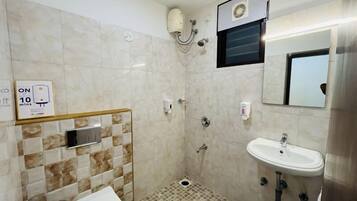 A small bathroom with a toilet, sink, and shower. There is a sign indicating a 10-minute limit.