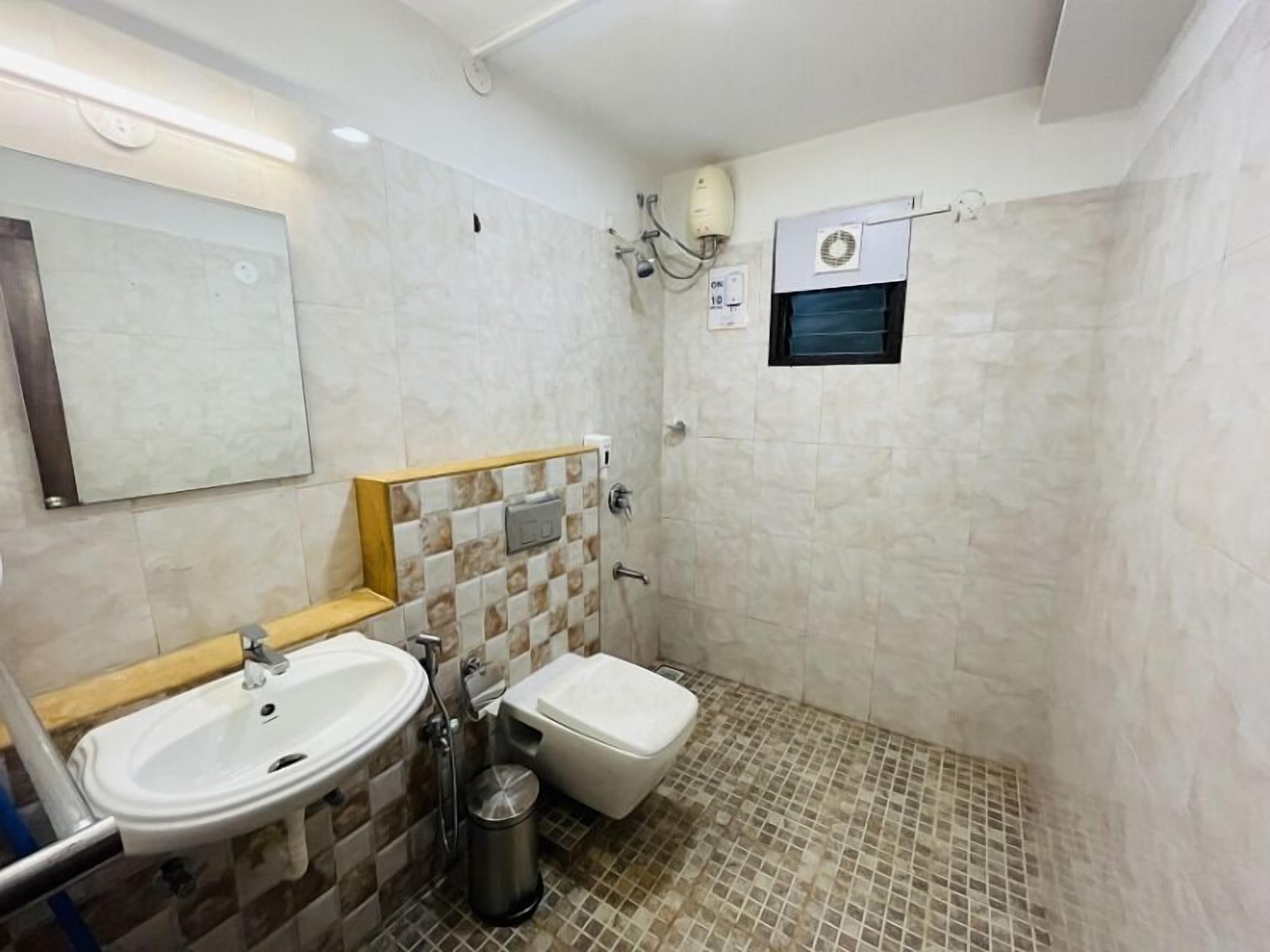Un baño con lavamanos, inodoro y zona de ducha.
