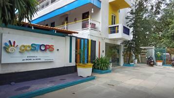 Un edificio con fachada colorida, un letrero que dice 'goSTOPS', y un texto que indica 'Ubicado justo en el corazón de la ciudad'.