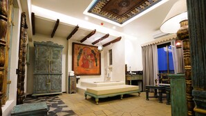 A traditional room with a large bed, a decorative cabinet, and a painting on the wall. - The Kinara Village (Mawal)