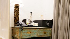 A compact hotel room with a small desk, a refrigerator, a telephone, and a lamp. - The Kinara Village (Mawal)