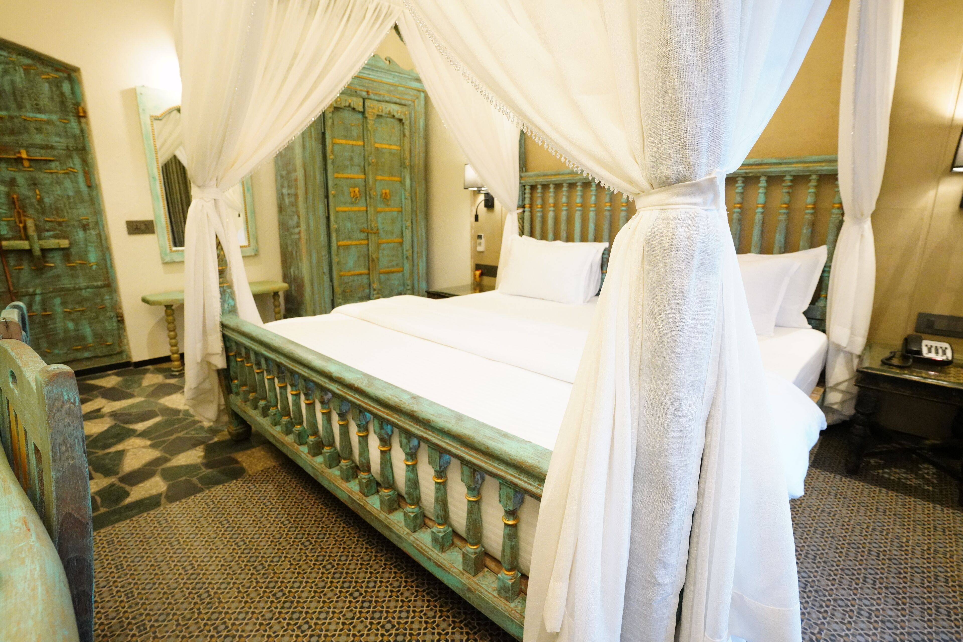 A bed with a canopy, a wooden headboard, and a patterned floor.