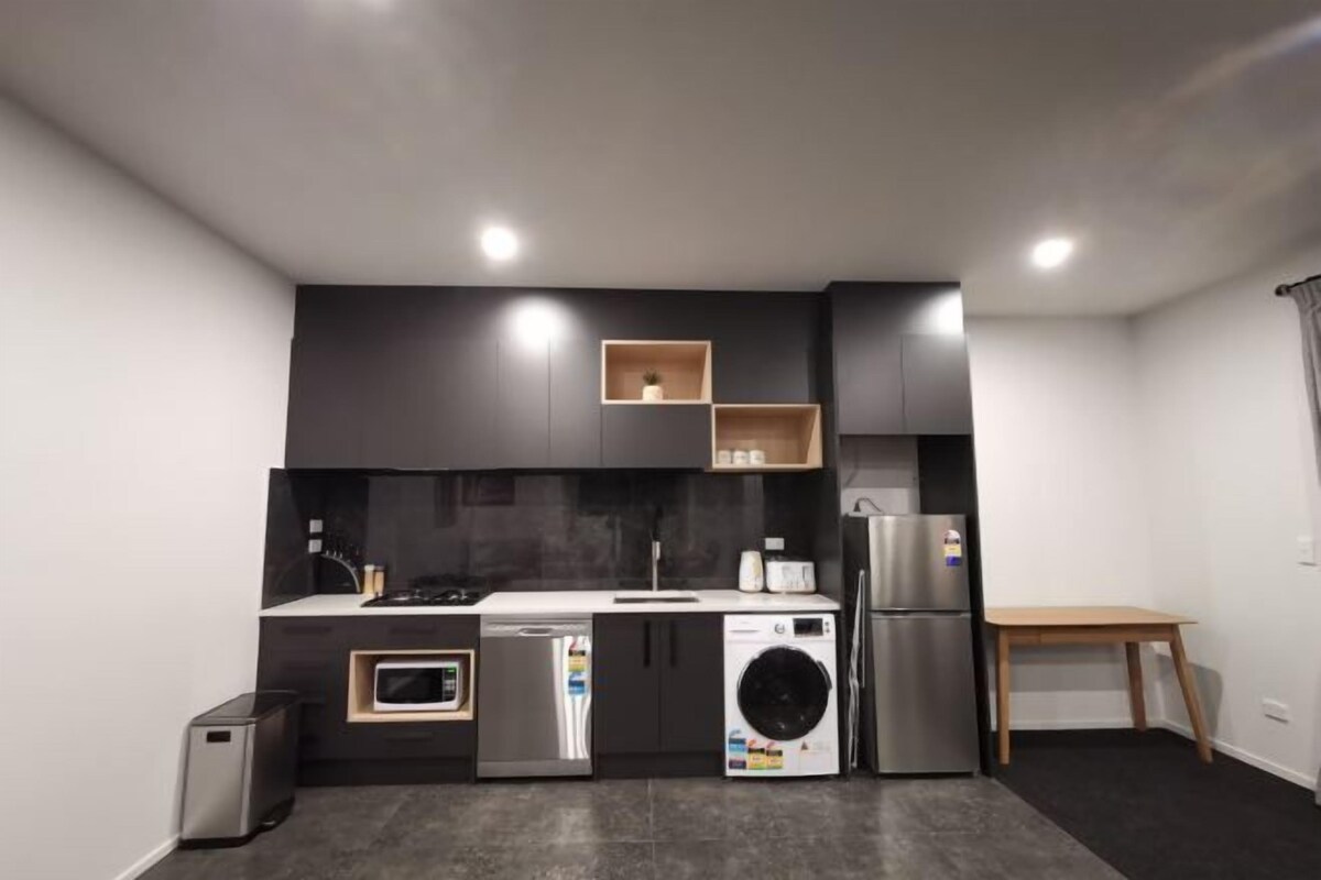 A modern kitchen with built-in appliances, a microwave, a dishwasher, and a refrigerator.