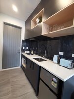 Frigorífico pequeño, microondas, placa de cocina y hervidor eléctrico