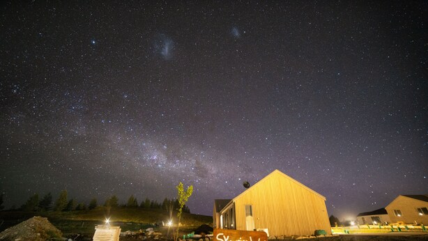 Un edificio llamado 'Skyrim Lodge' en Jimmy's Lane, con un cielo nocturno estrellado.