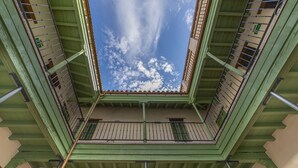 A view from a balcony looking up at a clear sky with clouds, featuring a green railing and a wooden floor. - Cantabria. 1-bedroom in the centre (Sevilla)