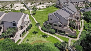 A coastal residential area with modern houses, a beach, and a boardwalk. - Sailmaker 612 - Hosted By Moore AI Rentals (Fernandina Beach)