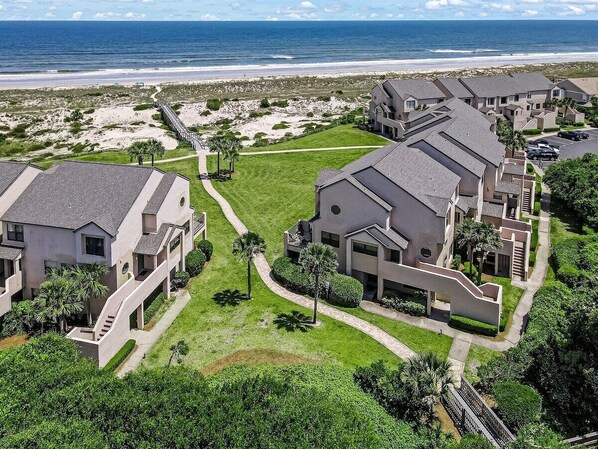 Una zona residencial costera con casas modernas, una playa y un paseo marítimo.