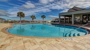 A swimming pool with a clear blue sky and palm trees in the background. - Sailmaker 612 - Hosted By Moore AI Rentals (Fernandina Beach)