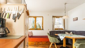 A compact living space with a kitchenette, a sofa, a dining table, and a coffee machine. - Apartment in Ramsau near Ski Slopes (Ramsau)