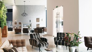 En rymlig entréhall med modern design, inredd med en blandning av sittgrupper, en öppen spis och ett stort fönster som släpper in naturligt ljus.
