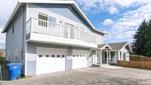 Une maison à deux étages avec un garage, un balcon et une véranda.