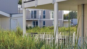 En bostadsbyggnad med en balkong, en grind vid entrén och ett teknikutrymme.