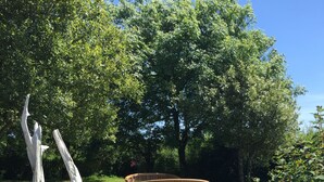 Un parque con un banco de madera y una escultura blanca distintiva.
