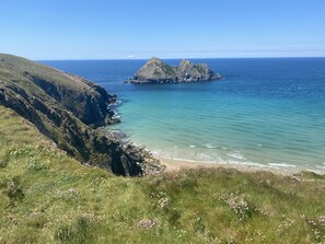 Eine Küstenlandschaft mit einem Felsen und tiefblauem Meer.