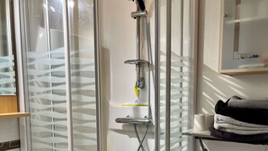 A modern bathroom with a glass-enclosed shower, a white sink, and a toilet. - L'hippocampe - Appt Mezzanine Centre D'arromanches (Arromanches-les-Bains)