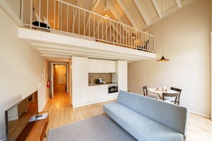 Ein Loft-Wohnraum mit Schlafgalerie, offener Küche und Essbereich.