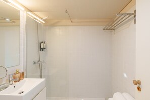 Ein Badezimmer mit Waschbecken, Spiegel und Dusche.