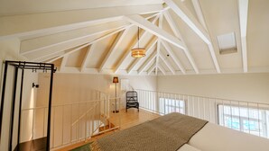 A spacious loft bedroom with a high ceiling, a staircase, and a view through large windows. - Brilliant Duplex Studio w/ Balcony for 3 in Center (Oporto)