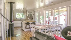 Una cocina moderna con una isla central, muebles blancos y un amplio ventanal que proporciona luz natural.