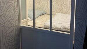 Une chambre à coucher avec un lit, une fenêtre et un papier peint à motifs.